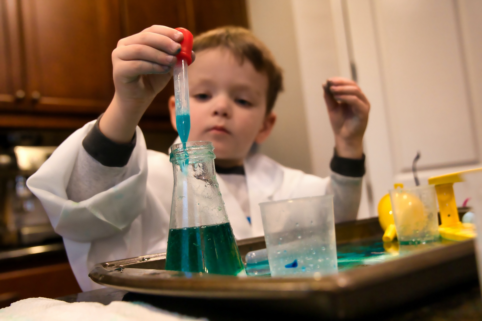 Kid experimenting with pipette and lab equipment